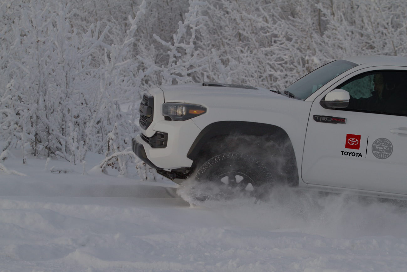 Toyota truck driving through snow